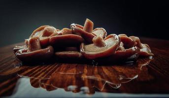 une dispersion de champignons marinés sur une table en bois. nourriture de village saine. champignon au lait noir salé . photo