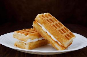 de délicieuses gaufres viennoises fraîches à la crème blanche se trouvent sur une assiette blanche. photo