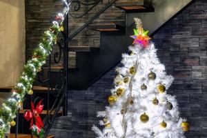 arbre de noël avec des décorations de noël à l'intérieur de la maison avec des escaliers élégants photo