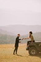 jeune couple se reposant sur un capot de véhicule tout-terrain à la campagne photo