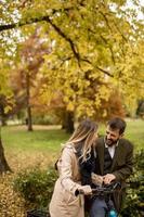 jeune couple dans le parc d'automne avec vélo électrique photo