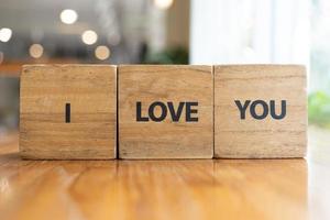 message je t'aime orthographié dans des blocs de bois avec espace de copie. Je t'aime mot écrit sur une cale en bois. Je t'aime texte sur table, concept. photo