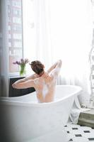 jeune femme heureuse prenant un bain à la maison, faites-vous plaisir photo