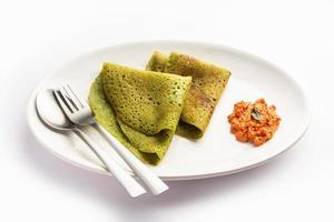 palak dosa fait en mélangeant des épinards ou du keerai dans une pâte, servi avec du chutney rouge photo