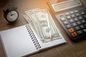 cahiers, stylos, montres et calculatrices sur le bureau en bois éléments de calcul dépenses de temps de finance d'entreprise photo