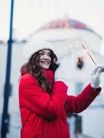 heureuse fille souriante marchant dans la rue avec des étincelles photo