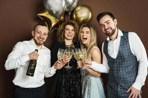 des fêtards bien habillés célébrant des vacances ou un événement et buvant du vin mousseux photo