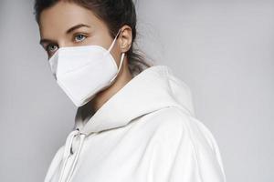 jeune femme portant un sweat à capuche blanc et un masque respiratoire ffp2 photo