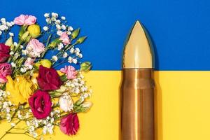 mouvement de pacifisme et de non-violence. balle et bouquet de fleurs différentes et drapeau ukrainien. photo