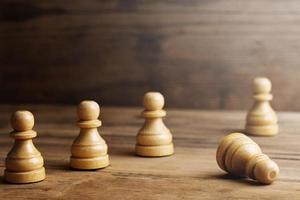 échecs en bois debout avec un pion d'échecs couché. photo