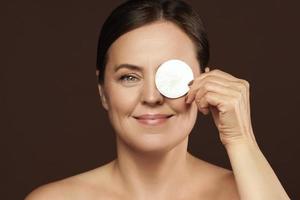 belle femme d'âge moyen avec des tampons de coton pour le nettoyage du visage ou la routine de démaquillage photo