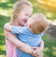 jeune frère et soeur serrant dans le parc photo