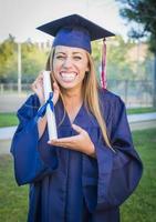 jeune femme expressive titulaire d'un diplôme en bonnet et robe photo