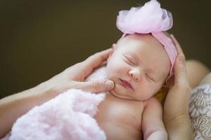 mains de mère tenant sa petite fille nouveau-née photo