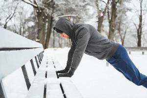 homme athlétique faisant des pompes pendant son entraînement d'hiver de gymnastique suédoise photo