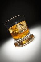 verre de whisky et de glace sous un projecteur. photo