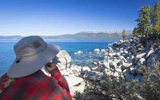 femme regardant par-dessus le beau rivage du lac tahoe. photo