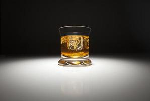 verre de whisky et de glace sous un projecteur. photo