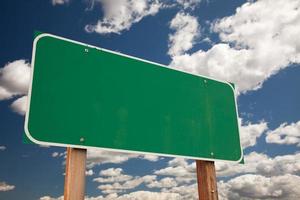 panneau de signalisation vert vierge au-dessus des nuages photo