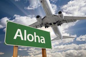 Panneau de signalisation vert aloha et avion au-dessus photo