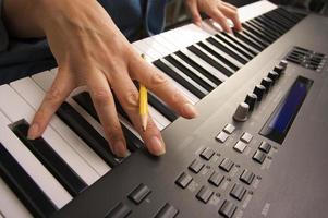 les doigts de la femme sur les touches du piano numérique photo