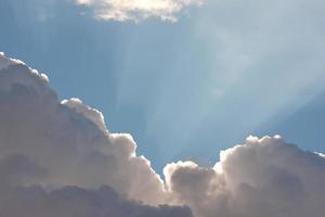 ciel bleu avec nuages et rayons de soleil photo