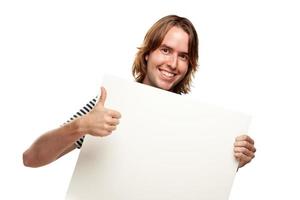 jeune homme souriant avec les pouces vers le haut tenant une pancarte blanche vierge photo