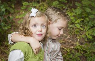 adorable frère et soeur enfants serrant dehors photo