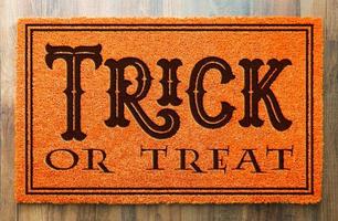 Trick or Treat halloween tapis de bienvenue orange sur fond de plancher en bois photo