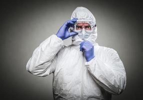 homme à l'expression intense portant des vêtements de protection contre les matières dangereuses sur fond gris. photo