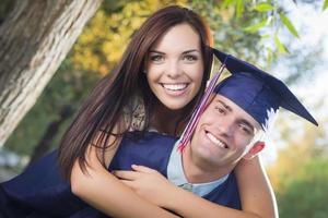 Diplômé masculin en bonnet et robe et fille célébrer photo