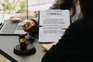 avocat masculin travaillant avec des documents contractuels et un marteau en bois sur table dans la salle d'audience. justice et droit, avocat, juge de la cour, concept. photo