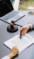 avocat masculin travaillant avec des documents contractuels et un marteau en bois sur table dans la salle d'audience. justice et droit, avocat, juge de la cour, concept. photo