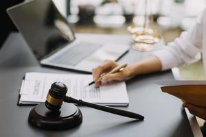 avocat masculin travaillant avec des documents contractuels et un marteau en bois sur table dans la salle d'audience. justice et droit, avocat, juge de la cour, concept. photo