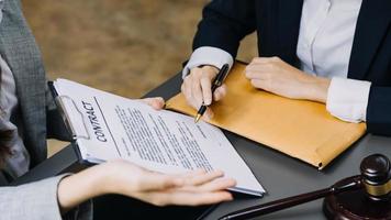 avocat masculin travaillant avec des documents contractuels et un marteau en bois sur table dans la salle d'audience. justice et droit, avocat, juge de la cour, concept. photo