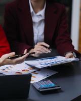 homme d'affaires et équipe analysant la tâche de financement des états financiers. avec téléphone intelligent et ordinateur portable et tablette. notion de gestion de patrimoine photo