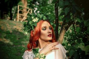 belle fille aux cheveux rouges avec une couronne sur la tête photo