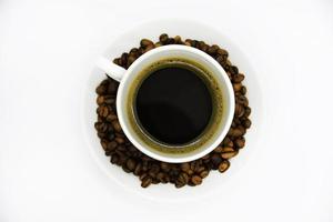 tasse à café en porcelaine sur fond blanc. délicieux café dans une tasse et des grains de café. photo