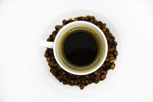 tasse à café en porcelaine sur fond blanc. délicieux café dans une tasse et des grains de café. photo