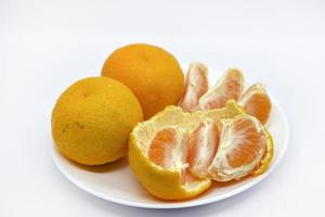 mandarines juteuses sur une assiette sur fond blanc. agrumes juteux. tranches de mandarines. photo