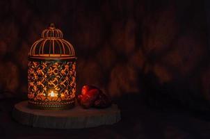 lanterne dorée et fruits de dattes sur fond sombre pour la fête musulmane du mois sacré du ramadan kareem. photo