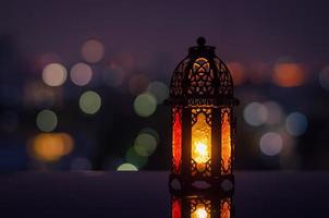 lanterne avec ciel nocturne et fond clair bokeh de la ville pour la fête musulmane du mois sacré du ramadan kareem. photo