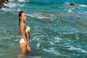 jeune fille s'amusant dans l'heure d'été de la mer photo