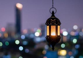 lanterne suspendue avec ciel nocturne et fond clair bokeh de la ville pour la fête musulmane du mois sacré du ramadan kareem. photo
