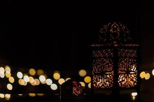 lanterne et fruits de dattes avec lumière bokeh sur fond sombre pour la fête musulmane du mois sacré du ramadan kareem. photo