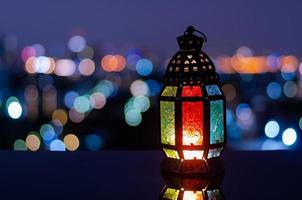 lanterne avec ciel nocturne et fond clair bokeh de la ville pour la fête musulmane du mois sacré du ramadan kareem. photo