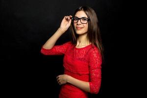 femme à lunettes et robe rouge regardant la caméra photo