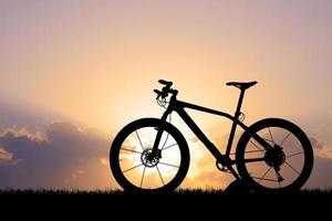 silhouette d'un vélo au coucher du soleil photo