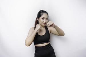 belle femme asiatique sportive fighter s'entraîne à la boxe en studio sur fond blanc. notion d'arts martiaux photo