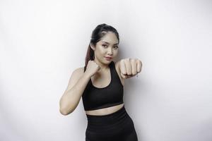 belle femme asiatique sportive fighter s'entraîne à la boxe en studio sur fond blanc. notion d'arts martiaux photo